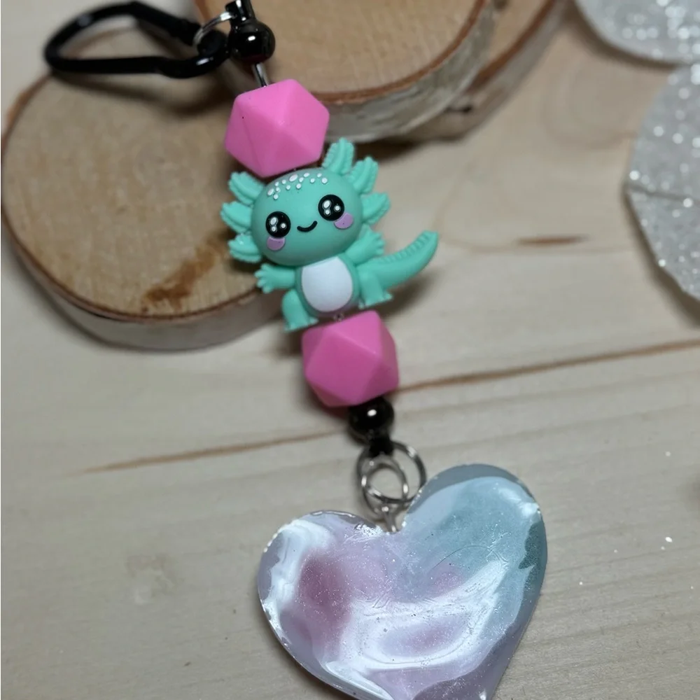 axolotl keychain with a pink and teal or blue resin heart pendant
